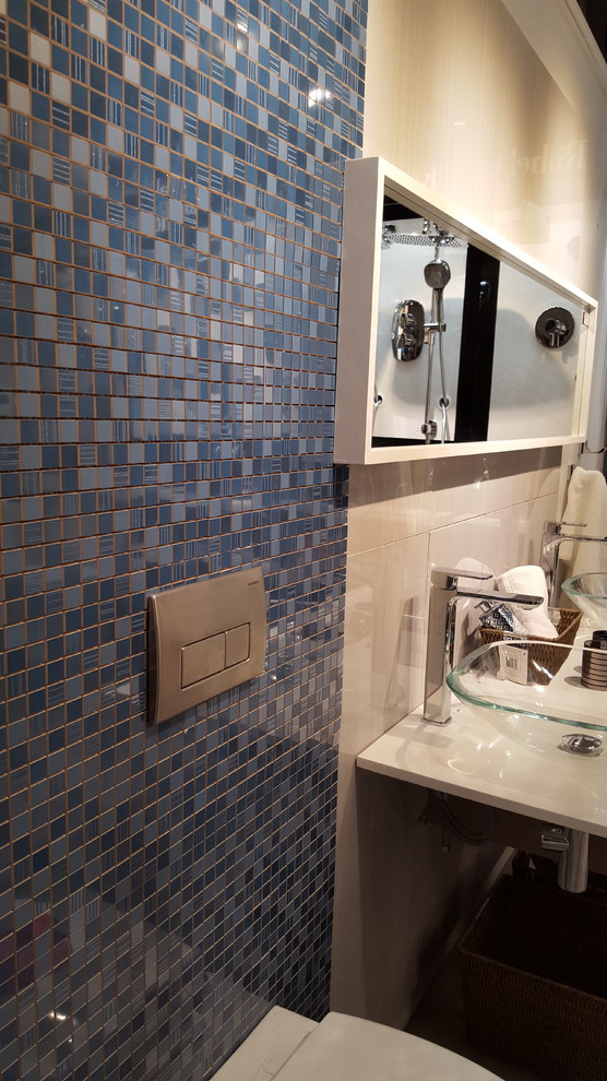Réalisation d'un grand WC suspendu minimaliste en bois clair avec un placard à porte plane, un carrelage bleu, des carreaux de céramique, un mur gris, parquet clair, une vasque et un plan de toilette en quartz.