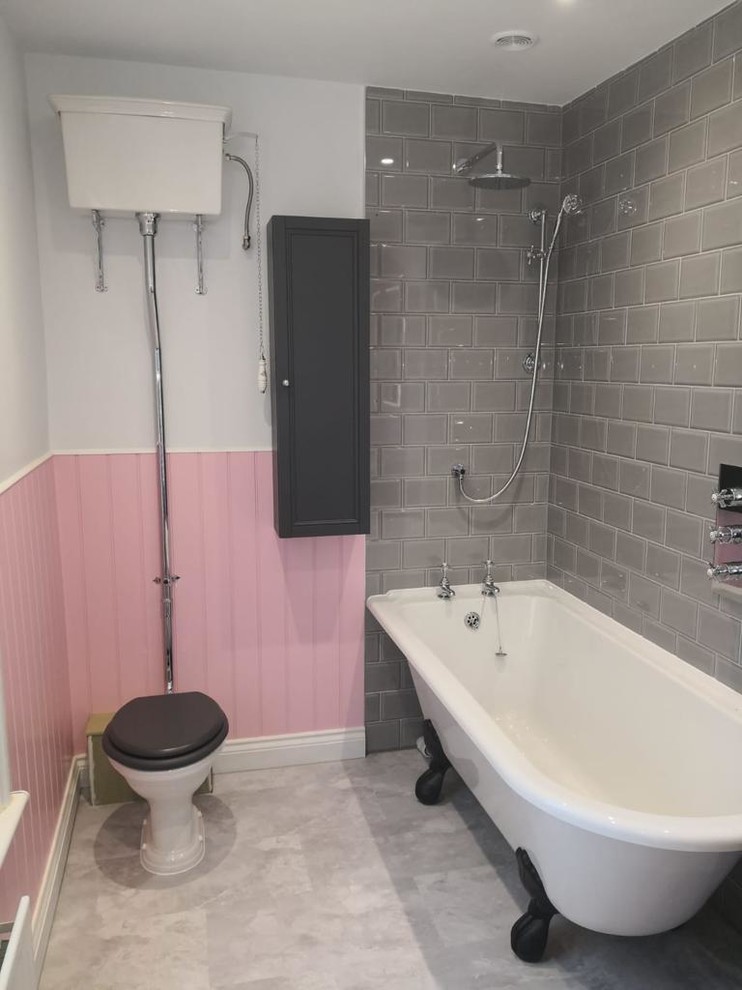 Medium sized victorian ensuite bathroom in Sussex with shaker cabinets, black cabinets, a freestanding bath, a shower/bath combination, a two-piece toilet, grey tiles, metro tiles, pink walls, porcelain flooring, a built-in sink, beige floors and a hinged door.