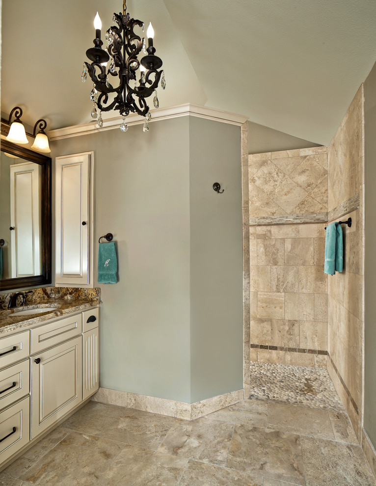 Klassisches Badezimmer mit verzierten Schränken, Granit-Waschbecken/Waschtisch, offener Dusche, Steinfliesen, grüner Wandfarbe und Travertin in Dallas