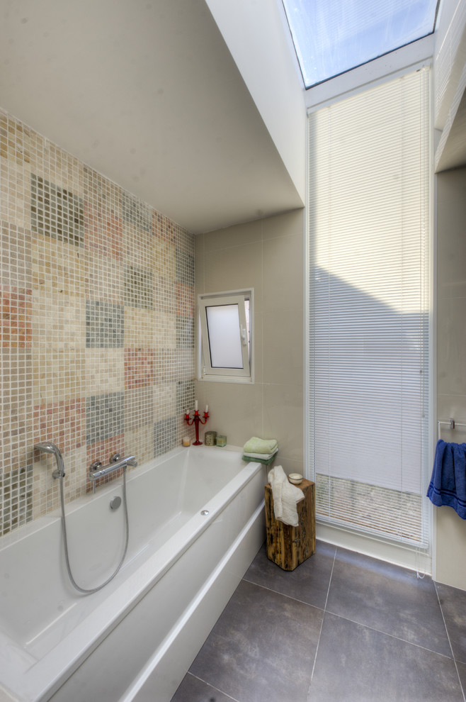 На фото: ванная комната в средиземноморском стиле с ванной в нише, разноцветной плиткой и плиткой мозаикой с
