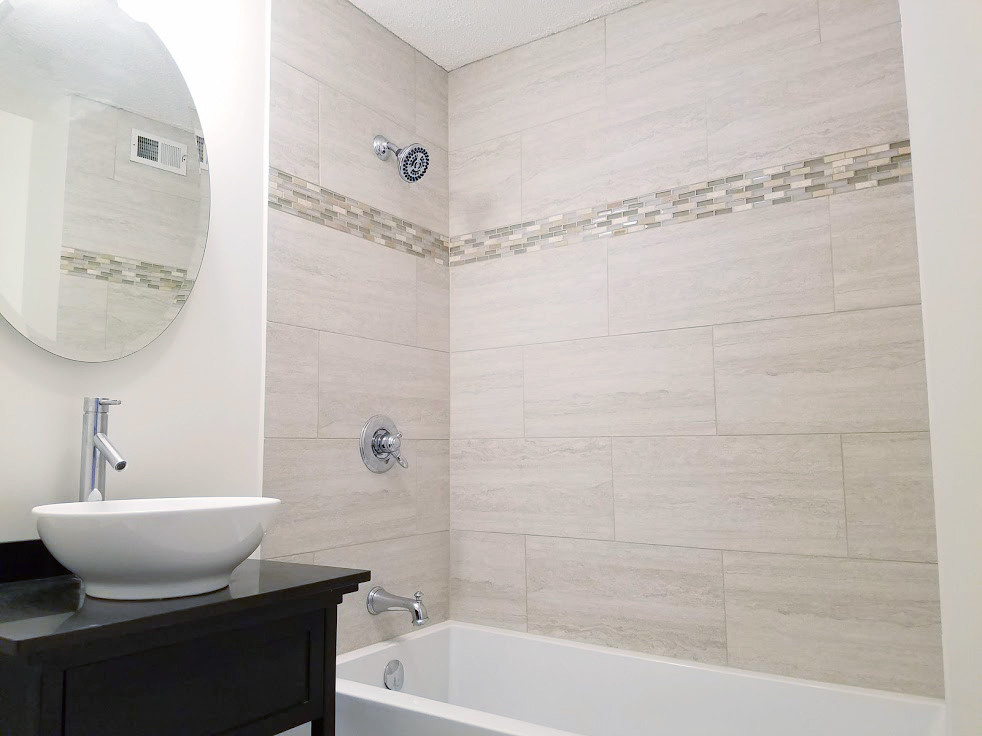 Klassisk inredning av ett mellanstort brun brunt en-suite badrum, med öppna hyllor, skåp i mörkt trä, ett badkar i en alkov, en dusch/badkar-kombination, en toalettstol med separat cisternkåpa, beige kakel, porslinskakel, vita väggar, klinkergolv i porslin, ett fristående handfat, bänkskiva i kvarts, vitt golv och med dusch som är öppen