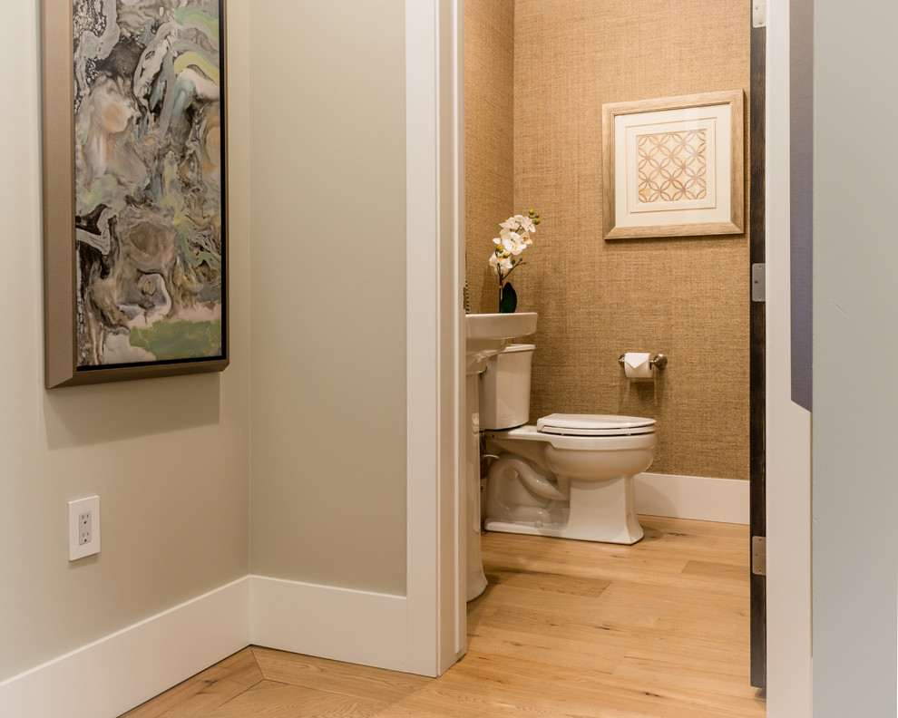 Inspiration pour un WC et toilettes traditionnel de taille moyenne avec parquet clair, un lavabo de ferme, WC à poser et un mur beige.
