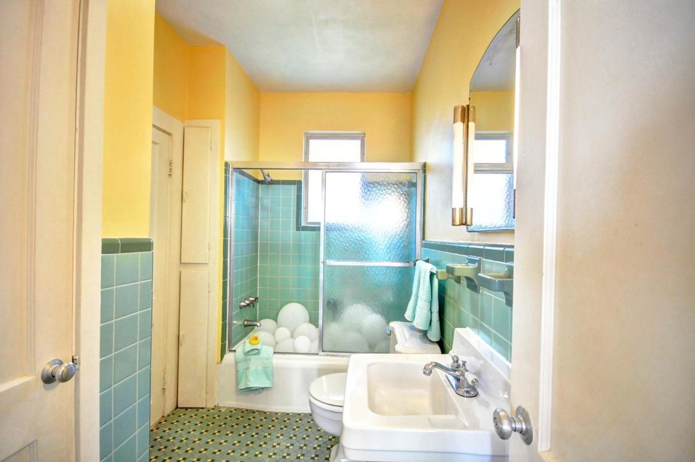 Idée de décoration pour une salle d'eau marine de taille moyenne avec une baignoire en alcôve, un combiné douche/baignoire, WC à poser, un carrelage bleu, des carreaux de céramique, un mur jaune, un sol en carrelage de céramique, un lavabo suspendu, un sol bleu et une cabine de douche à porte coulissante.