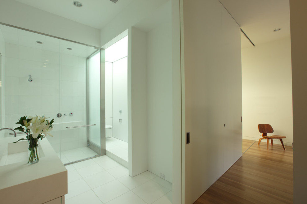 Immagine di una stanza da bagno contemporanea con lavabo integrato, doccia alcova e piastrelle bianche
