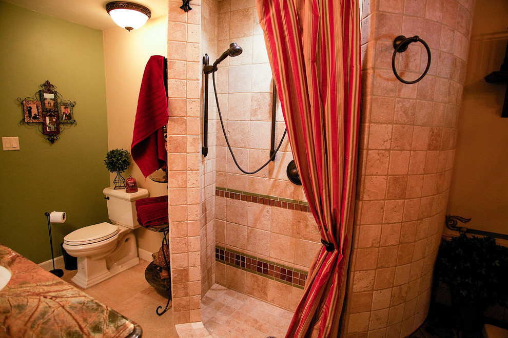 Idéer för ett mellanstort medelhavsstil badrum, med ett undermonterad handfat, granitbänkskiva, en dusch i en alkov, en toalettstol med separat cisternkåpa, beige kakel, stenkakel, travertin golv, luckor med upphöjd panel, gröna skåp, ett platsbyggt badkar och beige väggar