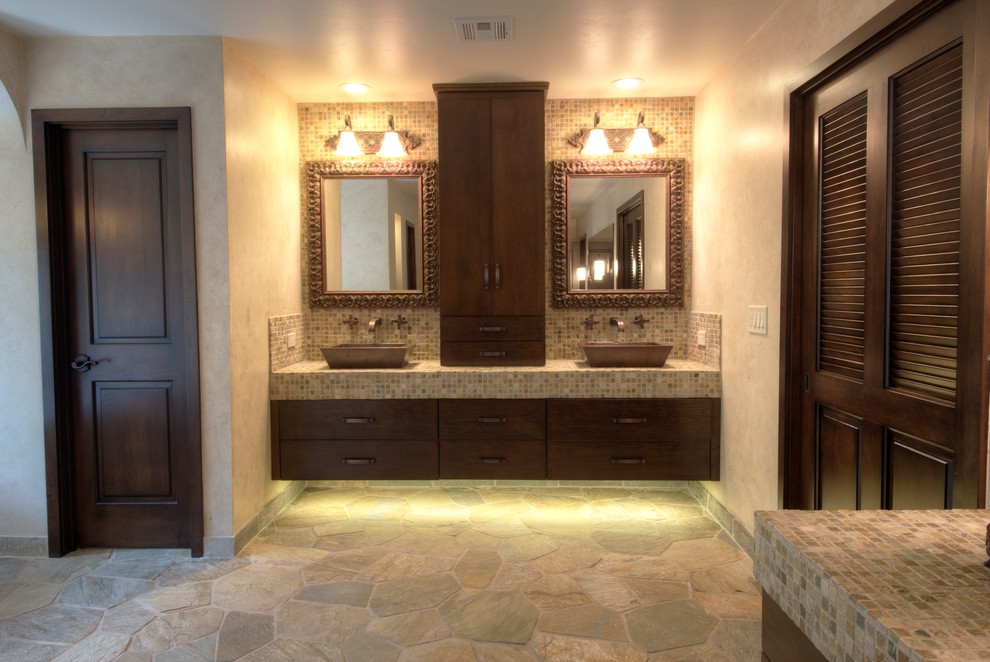 Inredning av ett eklektiskt stort en-suite badrum, med ett fristående handfat, skåp i mörkt trä, kaklad bänkskiva, ett fristående badkar, en dusch i en alkov, flerfärgad kakel, stenkakel, beige väggar och skiffergolv