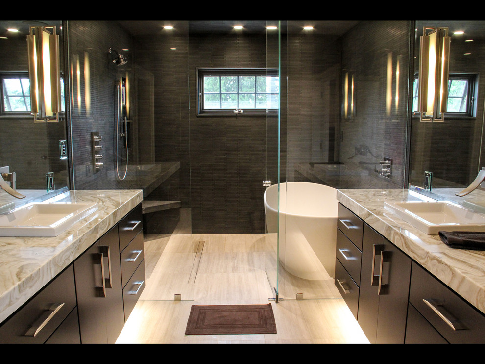 Foto di una stanza da bagno padronale chic di medie dimensioni con ante lisce, vasca freestanding, doccia a filo pavimento, piastrelle grigie e lavabo da incasso