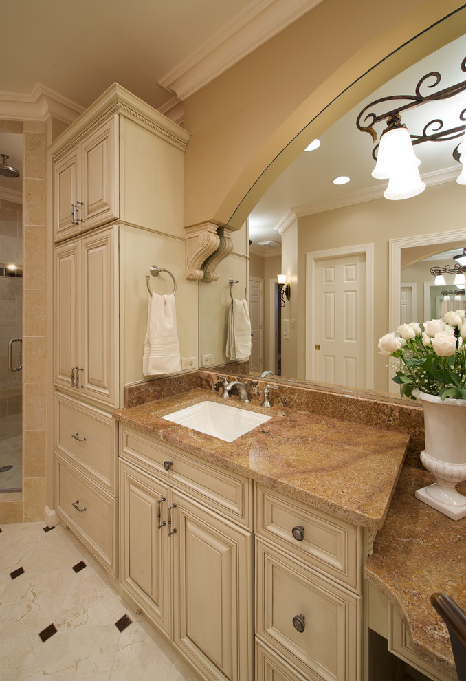 Idée de décoration pour une salle de bain tradition avec un placard avec porte à panneau surélevé, des portes de placard beiges et un lavabo encastré.