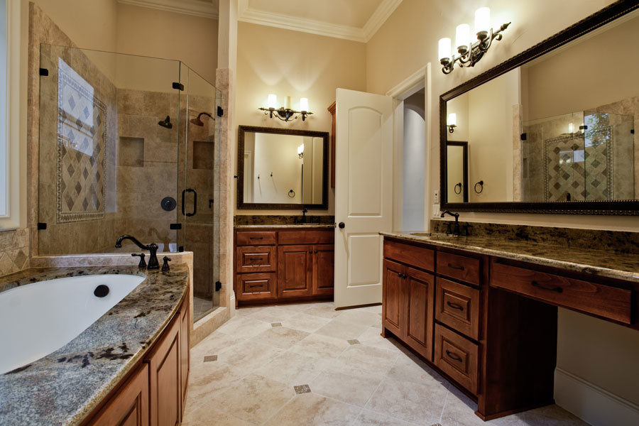 Foto di una stanza da bagno classica con ante con bugna sagomata, ante in legno bruno, vasca sottopiano, pareti beige, top in granito, doccia ad angolo e lavabo sottopiano