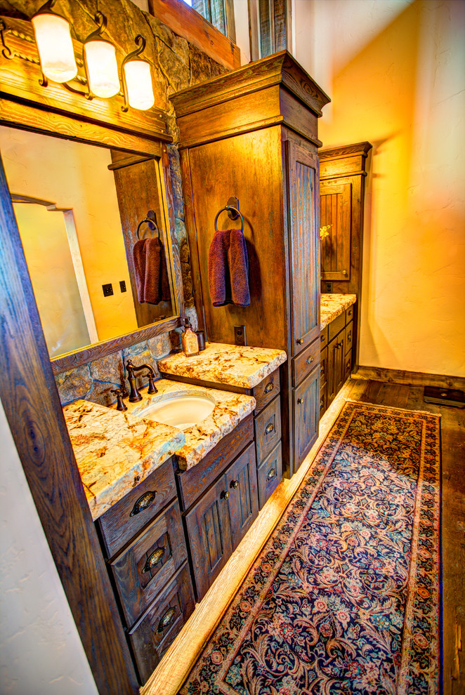 Imagen de cuarto de baño principal rústico grande con armarios con rebordes decorativos, puertas de armario de madera en tonos medios, encimera de granito, paredes blancas y suelo de madera en tonos medios