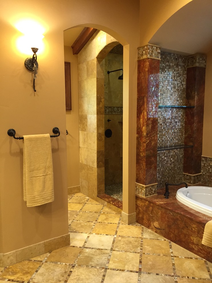 Foto de cuarto de baño mediterráneo con lavabo bajoencimera, baldosas y/o azulejos de piedra, paredes amarillas y suelo de travertino