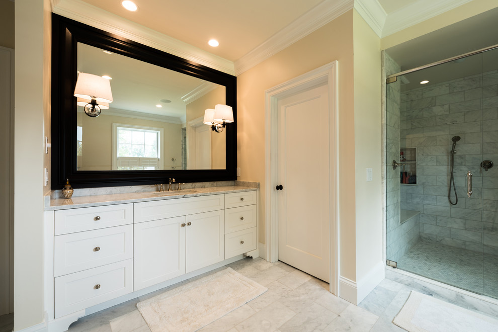 Bathroom - large transitional master gray tile and ceramic tile ceramic tile and gray floor bathroom idea in Cincinnati with shaker cabinets, white cabinets, beige walls, an undermount sink, marble countertops and a hinged shower door