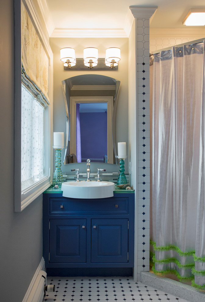 Cette image montre une salle de bain traditionnelle de taille moyenne avec une vasque, un placard avec porte à panneau surélevé, un plan de toilette en verre, un carrelage multicolore, un carrelage en pâte de verre, un mur gris et un sol en carrelage de céramique.