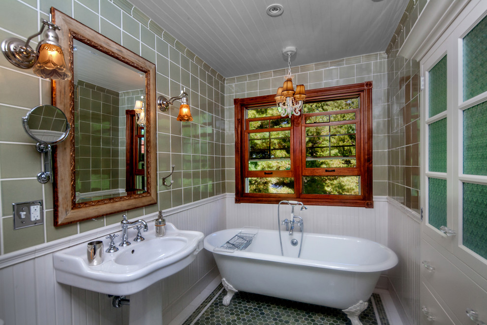Foto på ett mellanstort vintage badrum med dusch, med ett badkar med tassar, brun kakel, keramikplattor, bruna väggar, ett piedestal handfat och blått golv
