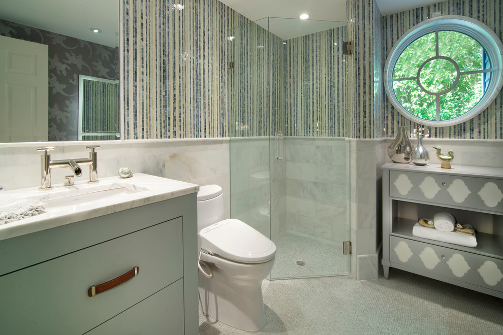 На фото: ванная комната среднего размера в морском стиле с врезной раковиной, плоскими фасадами, мраморной столешницей, раздельным унитазом, белой плиткой, каменной плиткой, разноцветными стенами, полом из травертина и синими фасадами с
