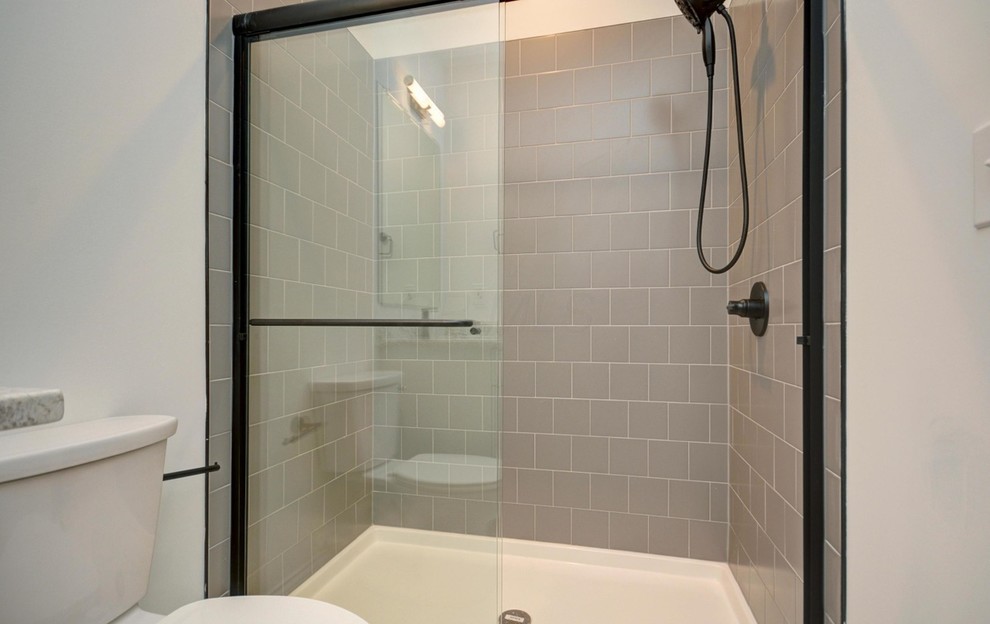 Design ideas for a medium sized traditional ensuite bathroom in Columbus with recessed-panel cabinets, white cabinets, an alcove shower, a two-piece toilet, grey tiles, white walls, ceramic flooring, a submerged sink, granite worktops, beige floors, a sliding door, multi-coloured worktops and porcelain tiles.