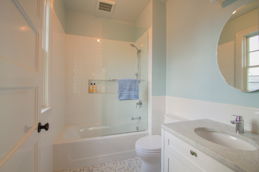 Medium sized traditional shower room bathroom in New York with a console sink, white cabinets, an alcove bath, a shower/bath combination, a two-piece toilet, white tiles, blue walls and ceramic flooring.