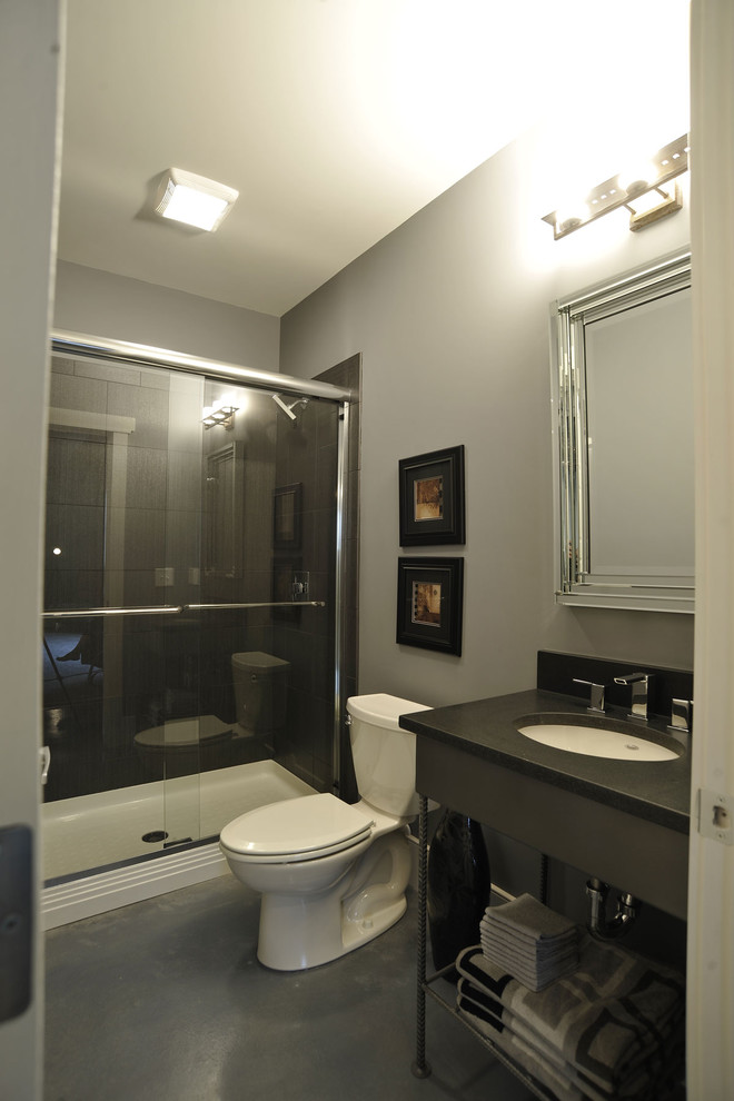 На фото: детская ванная комната в классическом стиле с бежевыми стенами, серым полом, серыми фасадами, душем в нише, раздельным унитазом, бетонным полом, врезной раковиной, душем с распашными дверями, черной столешницей, тумбой под одну раковину и напольной тумбой с