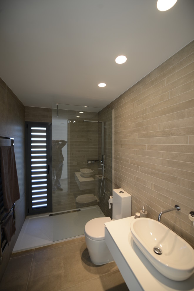 Mittelgroßes Modernes Duschbad mit Duschnische, Wandtoilette mit Spülkasten, beiger Wandfarbe, Keramikboden und Aufsatzwaschbecken in Sonstige