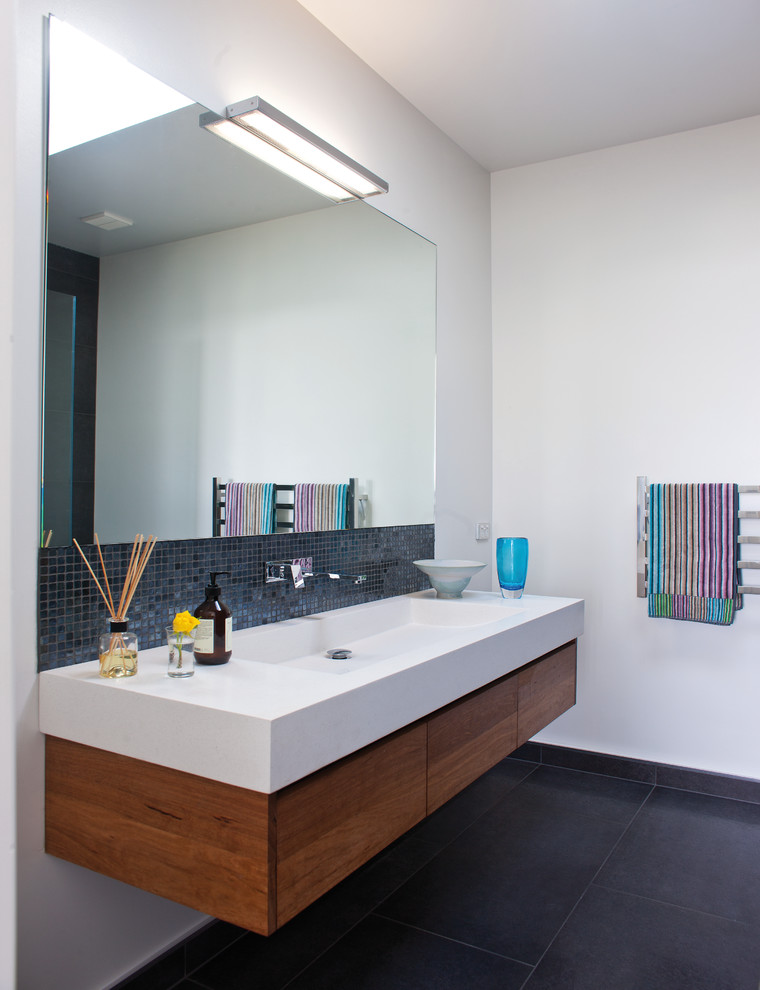 Idéer för ett modernt badrum, med ett integrerad handfat, svart kakel och mosaik