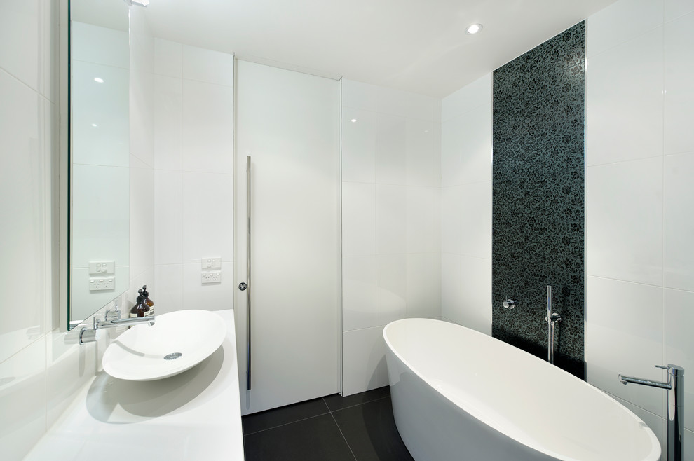 Idées déco pour une petite salle de bain moderne avec une vasque, un plan de toilette en quartz modifié, une baignoire indépendante, un carrelage blanc, des carreaux de céramique et un mur multicolore.