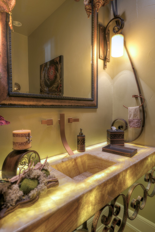 Идея дизайна: ванная комната в средиземноморском стиле с монолитной раковиной, столешницей из оникса и унитазом-моноблоком