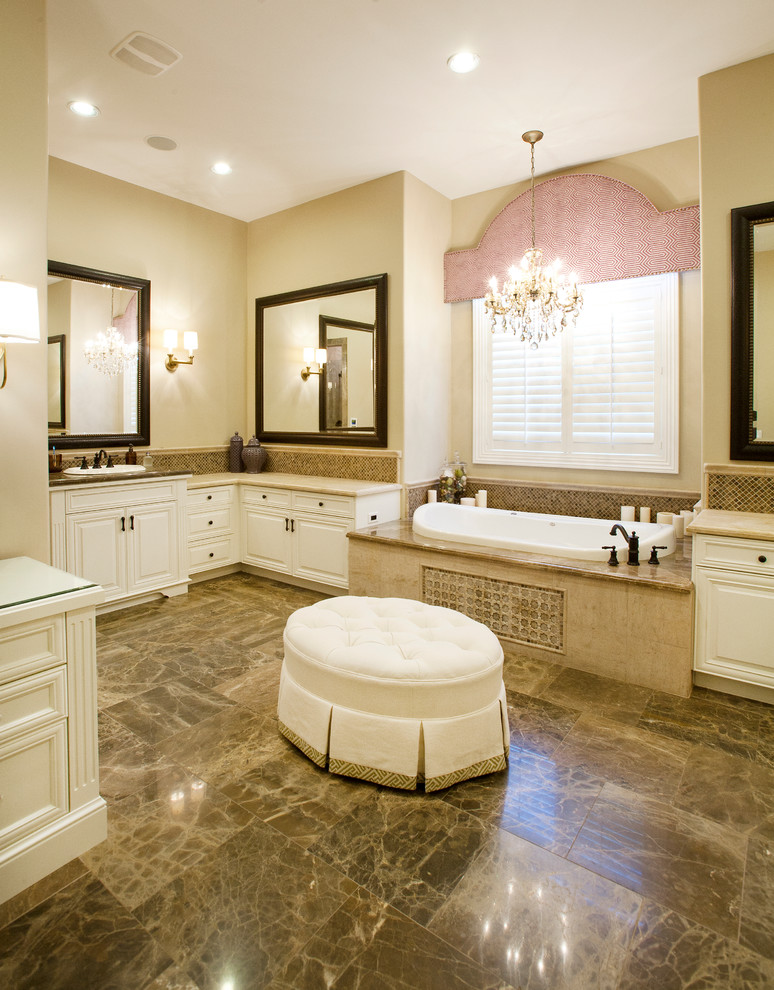 Mid-sized elegant master beige tile and stone tile marble floor bathroom photo in Las Vegas with raised-panel cabinets, white cabinets, a two-piece toilet, beige walls, a drop-in sink and marble countertops