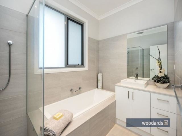 Modernes Badezimmer En Suite mit Schrankfronten mit vertiefter Füllung, weißen Schränken, Einbaubadewanne, offener Dusche, Toilette mit Aufsatzspülkasten, grauen Fliesen, Keramikfliesen, weißer Wandfarbe, Keramikboden, integriertem Waschbecken und Laminat-Waschtisch in Melbourne