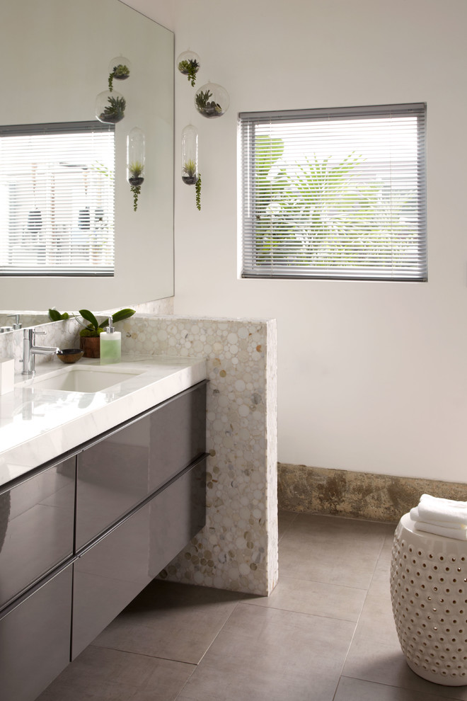 Foto di una stanza da bagno padronale minimalista con ante grigie, pareti bianche, pavimento in gres porcellanato e lavabo integrato