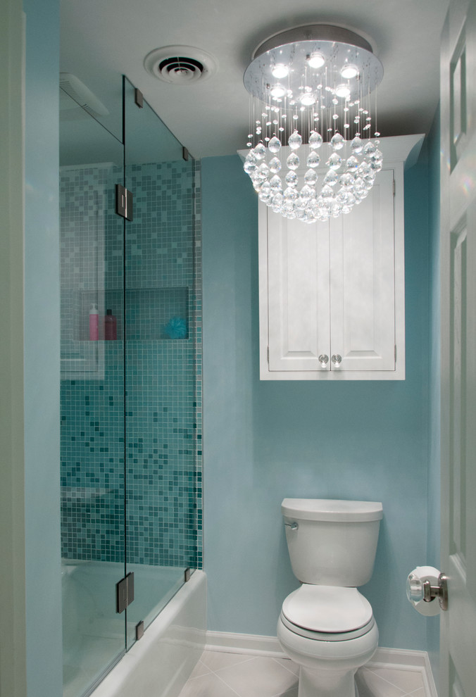 Cette image montre une douche en alcôve bohème de taille moyenne pour enfant avec une vasque, un placard avec porte à panneau surélevé, des portes de placard blanches, un plan de toilette en quartz modifié, une baignoire en alcôve, WC à poser, un carrelage bleu, mosaïque, un mur bleu, un sol en carrelage de porcelaine, un sol beige, une cabine de douche à porte battante et un plan de toilette blanc.