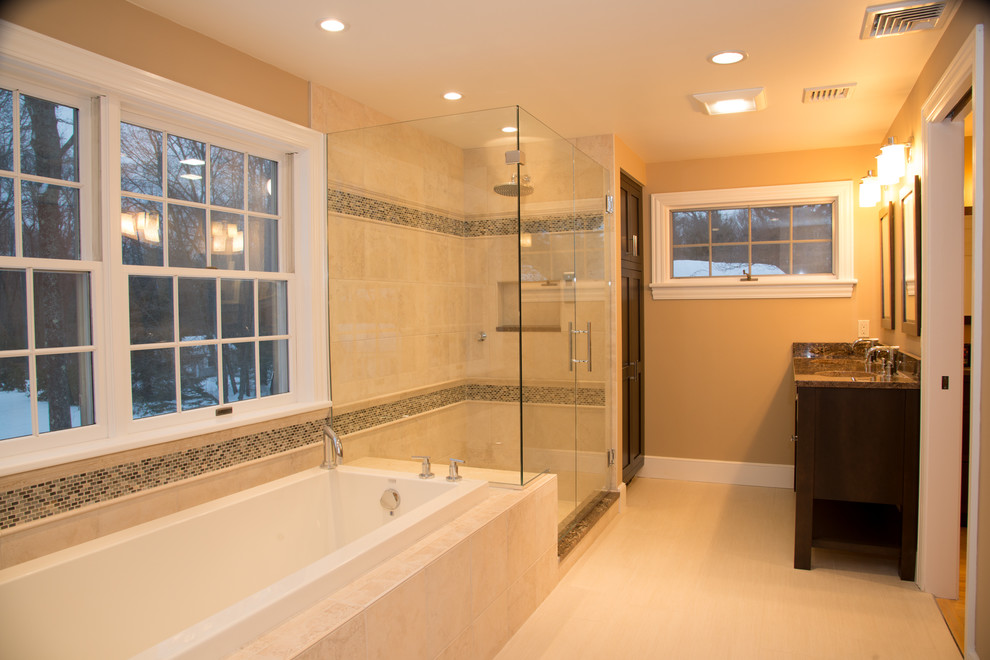 Transitional master beige tile drop-in bathtub photo in Boston with dark wood cabinets, beige walls and granite countertops