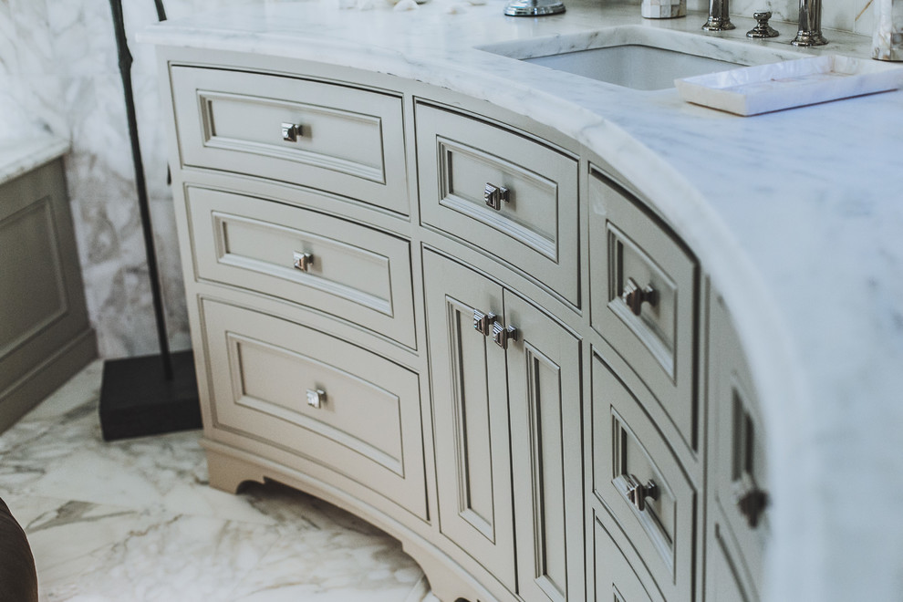 Inredning av ett klassiskt stort en-suite badrum, med luckor med profilerade fronter, grå skåp, ett undermonterat badkar, grå kakel, vit kakel, stenkakel, blå väggar, marmorgolv, ett undermonterad handfat och marmorbänkskiva