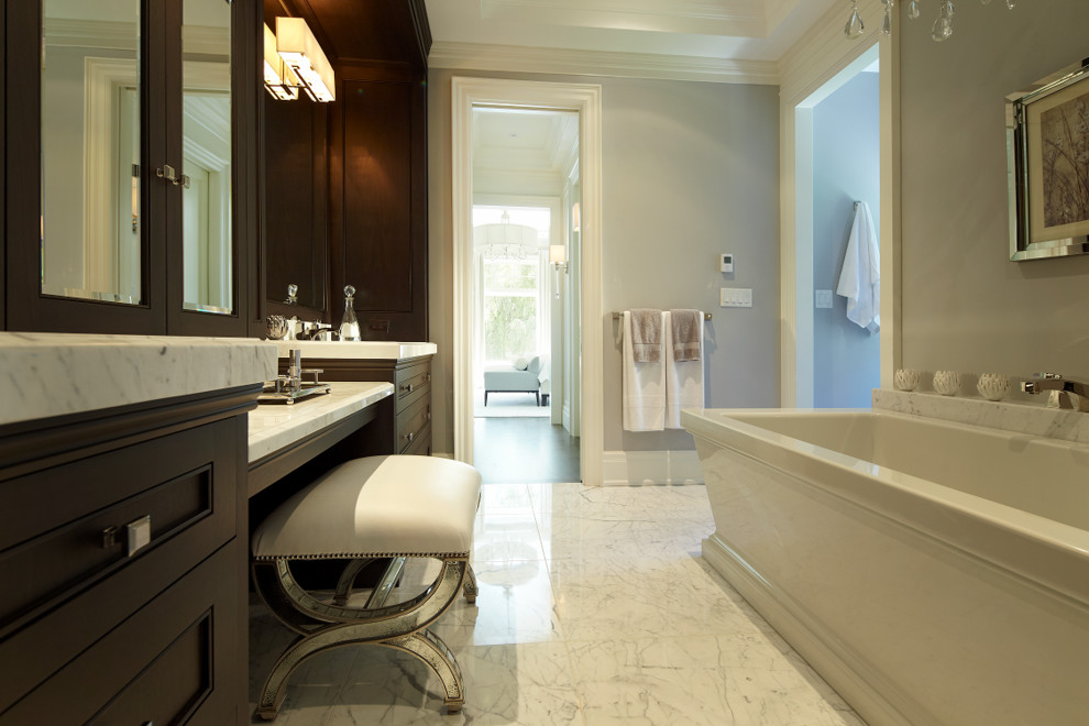 Inspiration for a large transitional master white tile and stone tile marble floor bathroom remodel in Toronto with beaded inset cabinets, dark wood cabinets, a one-piece toilet, gray walls, an undermount sink and marble countertops