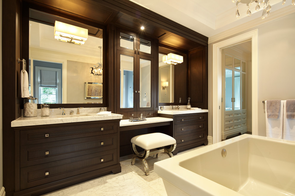 Exempel på ett stort klassiskt badrum, med luckor med profilerade fronter, skåp i mörkt trä, ett fristående badkar, en öppen dusch, en toalettstol med hel cisternkåpa, vit kakel, stenkakel, grå väggar, marmorgolv, ett undermonterad handfat och marmorbänkskiva