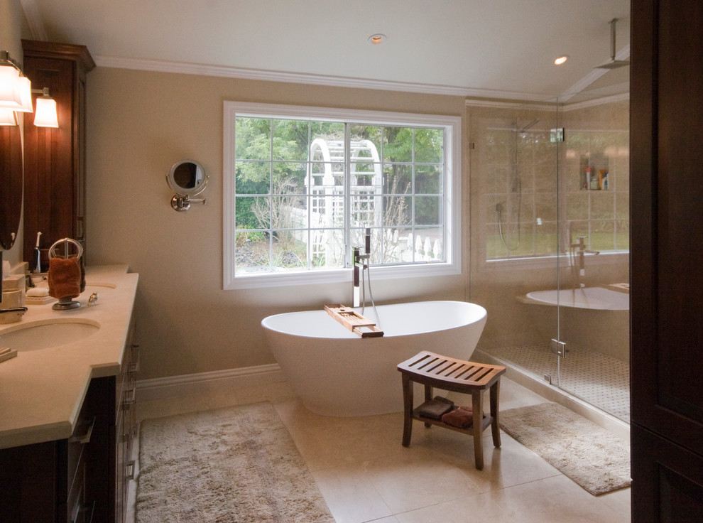 Medium sized traditional ensuite bathroom in San Francisco with a submerged sink, raised-panel cabinets, dark wood cabinets, granite worktops, a freestanding bath, a corner shower, a one-piece toilet, beige walls and limestone flooring.