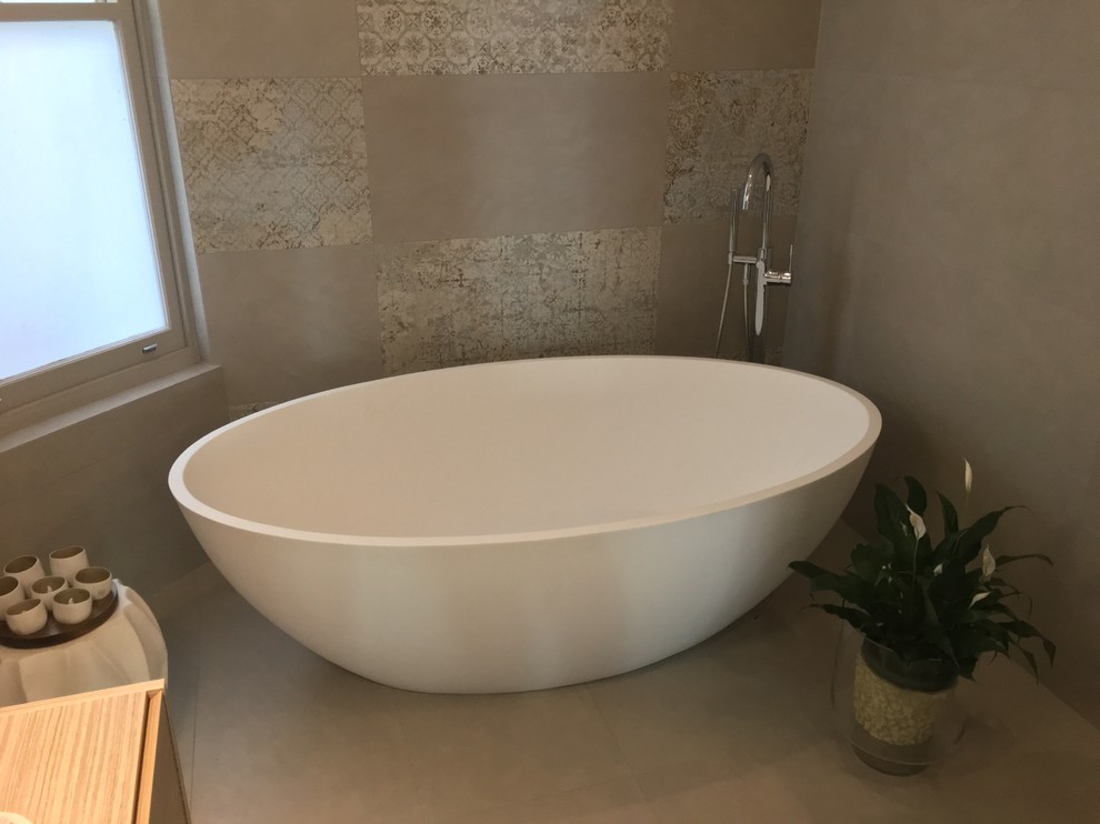 Inspiration for a large modern ensuite bathroom in Sydney with raised-panel cabinets, white cabinets, a freestanding bath, a walk-in shower, multi-coloured tiles, stone tiles, porcelain flooring, a vessel sink and solid surface worktops.