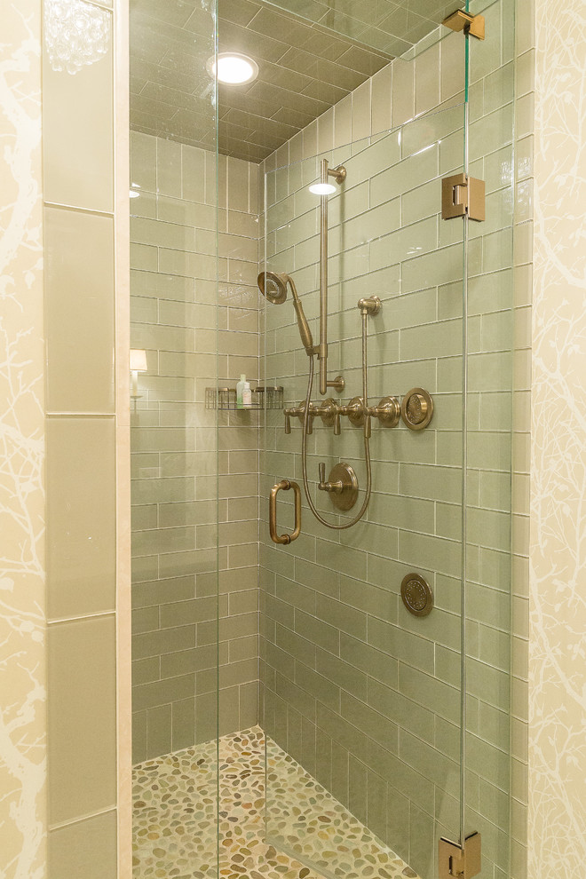 Photo of a medium sized traditional shower room bathroom in New York with flat-panel cabinets, medium wood cabinets, an alcove bath, an alcove shower, a two-piece toilet, green tiles, glass tiles, multi-coloured walls, pebble tile flooring, a vessel sink and quartz worktops.