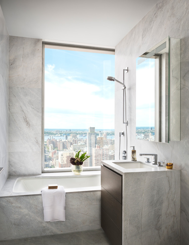 На фото: ванная комната в современном стиле с плоскими фасадами, темными деревянными фасадами, полновстраиваемой ванной, душем над ванной, серой плиткой и врезной раковиной с