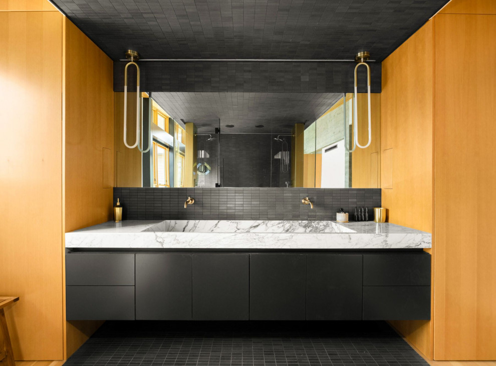 Exempel på ett modernt flerfärgad flerfärgat en-suite badrum, med släta luckor, svarta skåp, en kantlös dusch, svart kakel, mosaikgolv, ett avlångt handfat, marmorbänkskiva, svart golv och dusch med gångjärnsdörr