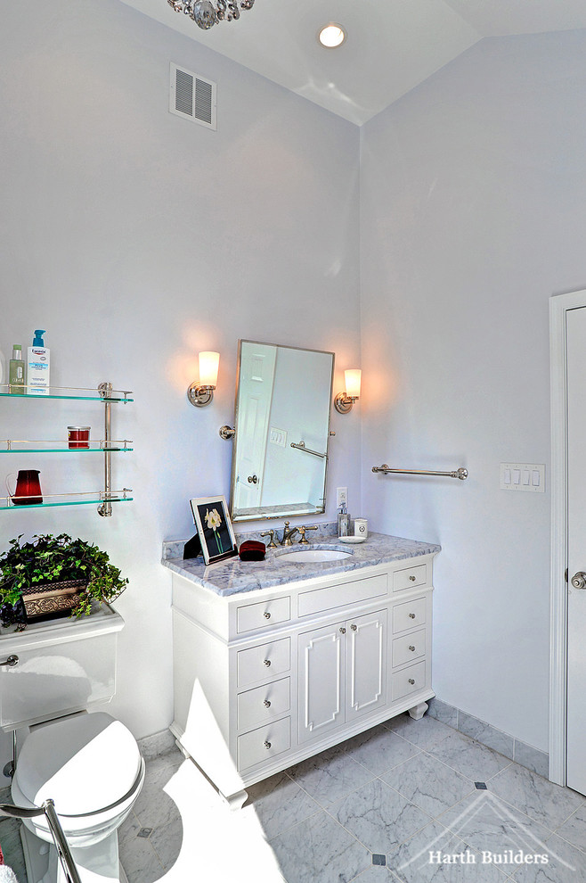 Bild på ett mellanstort vintage en-suite badrum, med släta luckor, vita skåp, en toalettstol med separat cisternkåpa, grå kakel, stenkakel, grå väggar, marmorgolv, ett väggmonterat handfat och marmorbänkskiva