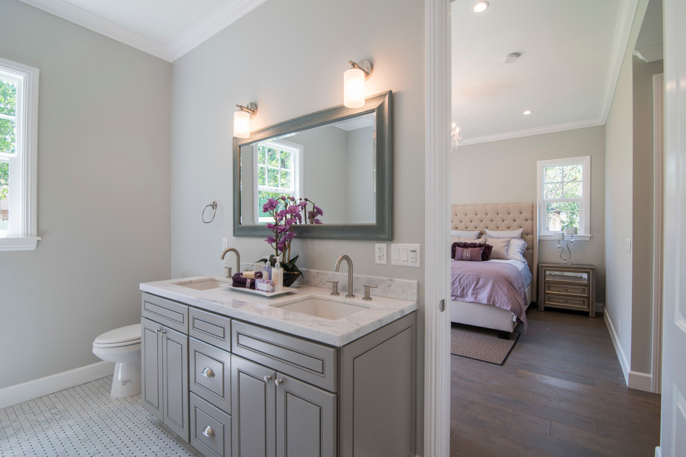 Esempio di una stanza da bagno padronale tradizionale di medie dimensioni con ante con bugna sagomata, ante grigie, WC a due pezzi, pareti grigie, lavabo sottopiano, top in marmo, pavimento bianco e top bianco