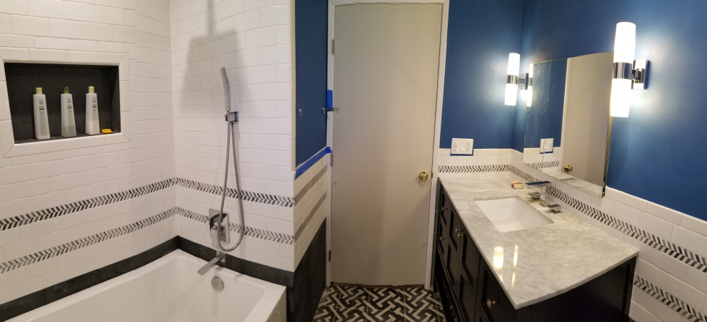 Cette photo montre une salle de bain principale rétro de taille moyenne avec un placard à porte shaker, des portes de placard noires, une baignoire posée, un combiné douche/baignoire, WC à poser, un carrelage blanc, des carreaux de céramique, un sol en carrelage de porcelaine, un lavabo encastré, un plan de toilette en quartz, un sol multicolore, une cabine de douche avec un rideau, un plan de toilette multicolore, une niche, meuble simple vasque et meuble-lavabo sur pied.