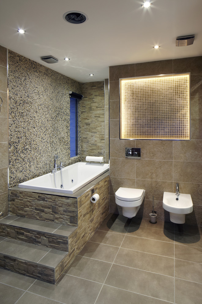 Ejemplo de cuarto de baño rectangular actual con bañera encastrada y piedra