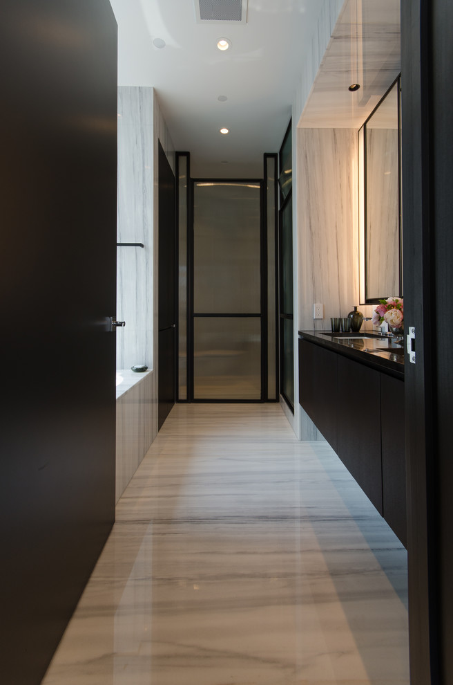 Idee per un'ampia stanza da bagno padronale moderna con ante lisce, ante nere, vasca sottopiano, doccia doppia, pavimento in marmo e top in marmo