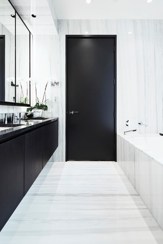 Стильный дизайн: ванная комната в стиле модернизм с плоскими фасадами, темными деревянными фасадами, полновстраиваемой ванной, белой плиткой, плиткой из листового камня, белыми стенами и мраморным полом - последний тренд