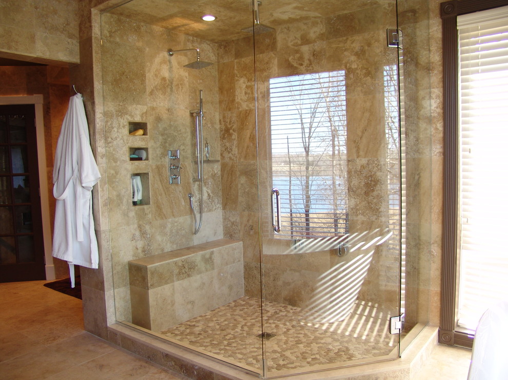 На фото: огромная главная ванная комната в стиле модернизм с настольной раковиной, угловым душем, коричневой плиткой, галечной плиткой, бежевыми стенами и полом из травертина