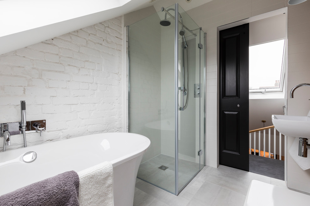 Esempio di una stanza da bagno minimal di medie dimensioni con vasca freestanding, doccia ad angolo, pareti bianche, lavabo sospeso e pavimento grigio