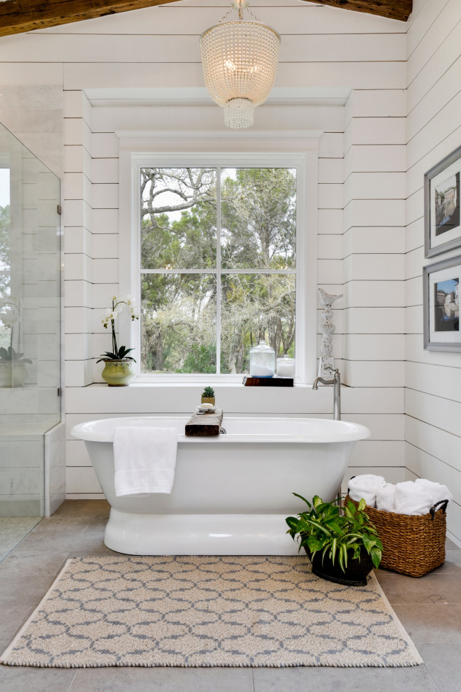Rustikales Badezimmer En Suite mit freistehender Badewanne, weißer Wandfarbe, grauem Boden, gewölbter Decke und Holzdielenwänden in Austin