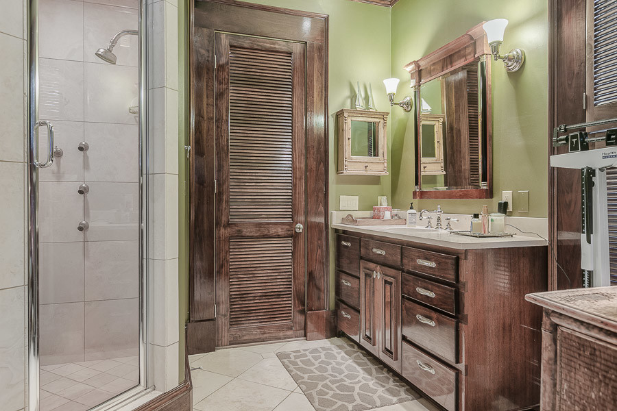 Immagine di una stanza da bagno padronale di medie dimensioni con ante lisce, ante marroni, doccia ad angolo, piastrelle beige, piastrelle in ceramica, pareti verdi, pavimento con piastrelle in ceramica, lavabo sottopiano e top in marmo