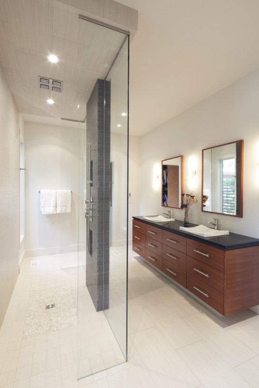 Esempio di una stanza da bagno con doccia design di medie dimensioni con lavabo da incasso, doccia a filo pavimento, pareti bianche, ante lisce, ante in legno scuro, top in granito e piastrelle nere
